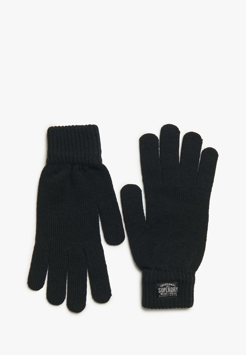 Guantes de lana negros con puños acanalados, con una etiqueta que dice "Ropa de Trabajo Tradicional Superdry". Textura suave y diseño ajustado.