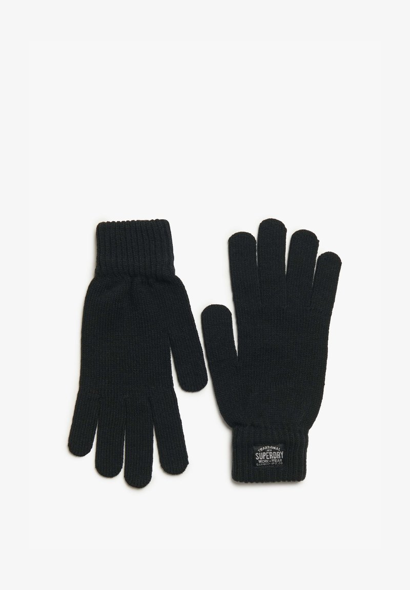 Guantes de lana negros con puños acanalados, con una etiqueta que dice "Ropa de Trabajo Tradicional Superdry". Textura suave y diseño ajustado.