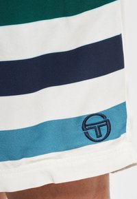 Miesten shortsit, joissa on vihreitä, laivastonsinisiä, valkoisia ja sinivihreitä vaakaraitoja. Puuvillakangasta, jossa tehostevärikkäällä ja laivastonsinisellä kirjailulla koristeltu logo helmassa.