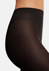 Collant neri opachi con una texture liscia, dotati di un pannello in vita semi-trasparente e un design a vita alta per una maggiore copertura.