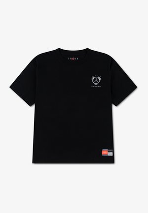 Sort t-shirt med korte ærmer, et lille hvidt Jordan-logo på venstre bryst og et flerfarvet mærke nær den nederste kant. Ingen synlige personer.