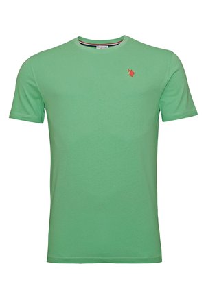 Zielona bawełniana koszulka z okrągłym dekoltem, krótkim rękawem i małym czerwonym haftowanym logo po lewej stronie klatki piersiowej. Miękka, gładka tekstura.