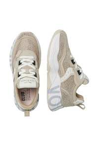 Beige SportSneaker mit metallischen Akzenten, strukturiertem Mesh, weißen Schnürsenkeln, einer gemusterten Sohle und Branding an der Zunge und Ferse.