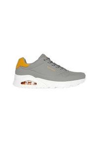 Grijze sneaker met gele accenten, glad synthetisch bovenmateriaal, ronde neus, vetersluiting, verhoogde witte zool en zichtbare luchtkussentjes.