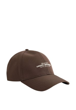 Brown baseball cap with curved brim and white text logo reading "GANT Original Shirtmakers Genuine. Classic est 1949" on front.