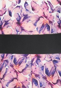 Υφασμα με λουλούδια, με μεγάλα ροζ και μοβ άνθη και φαρδιά μαύρη ζώνη στη μέση.