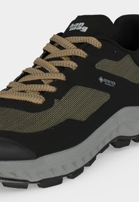 Μαύρο και μπεζ παπούτσι πεζοπορίας με κορδόνια με σχέδιο, ετικέτα Gore-Tex Invisible Fit και ανθεκτική γκρι σόλα σχεδιασμένη για υπαίθρια χρήση.
