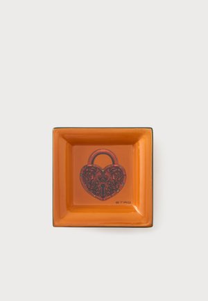 Orange square dish featuring an ornate heart-shaped padlock design and the word ETRO in the lower right corner.