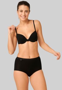 Set di reggiseno nero senza cuciture e slip a vita alta. Tessuto morbido ed elastico con una texture liscia. Spalline regolabili e dettagli del logo discreti sulla vita.