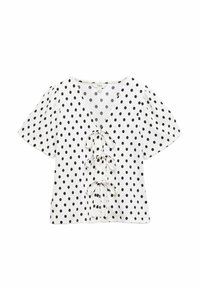 Hvid top med sorte polkaprikker, dyb V-udskæring og korte puffede ærmer. Har tre bindebånd fremme. Blød tekstur.