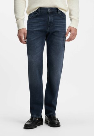 Mørkeblå straight-leg jeans båret med sorte lædersko og en cremefarvet langærmet sweater.
