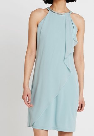 Jasnoniebieska sukienka na szyję z falbaną z przodu i zdobionym dekoltem, wykonana z miękkiego, lejącego materiału.