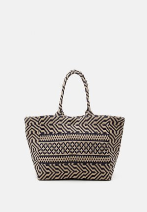 Große Tragetasche mit schwarzen und beigen geometrischen und Kreuzmustern, ausgestattet mit zwei runden Griffen, vor weißem Hintergrund präsentiert.