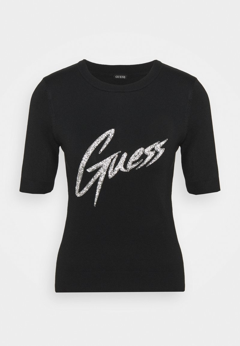 Černé krátké rukávy pletené tričko s kulatým výstřihem, s velkým stříbrným glitrovým logem "Guess" přes hrudník.