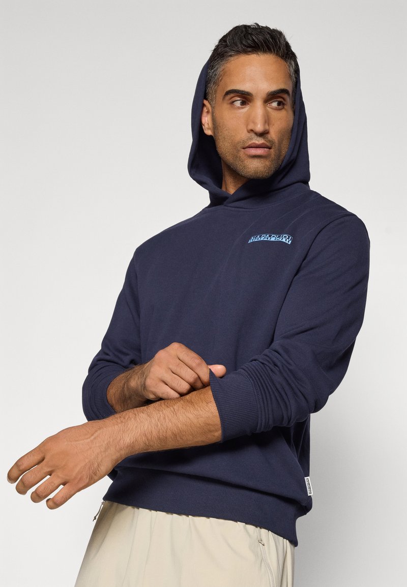 Felpa navy in cotone, presenta un design semplice con tasca frontale a marsupio e polsini a costine. Include un piccolo dettaglio del logo blu.