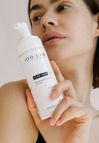 Biała butelka pianki do twarzy IDO.LAB ALOE+Zinc z pompką, czarnym tekstem i etykieta zawierającą informacje o użyciu produktu i pojemności (150 ml).