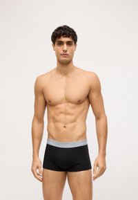 Crne bokserice sivoj pojasu s logotipom "Calvin Klein". Glatka tkanina, prilagođen dizajn i udoban oblik.