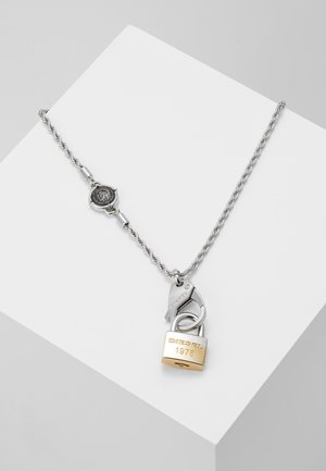Collar de cadena plateada con un cierre de plata y un colgante de candado en tono dorado grabado con "DIESEL 1978".