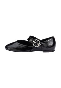 Chaussure plate en cuir verni noir avec bout pointu et bride de cheville. Présente une boucle en métal et des détails de couture. Semelle à profil bas.