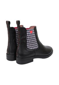 Czarne skórzane botki za kostkę o teksturowanym wykończeniu, z wzorzystymi panelami materiałowymi i małym czerwonym sercem na boku.