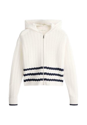 Bijela dukserica s kapuljačom na patentni zatvarač s teksturiranim valovitim uzorkom, s tri horizontalne crne pruge blizu struka i crnim rubom na manžetama.