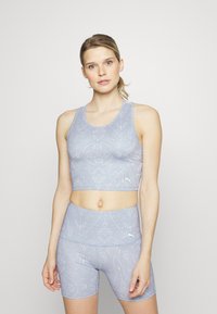 Conjunto de top desportivo azul claro e calções de cintura alta. Tecido suave e elástico com um padrão. Pouca ferragem, estilo nadador.