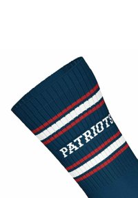 Calcetín azul con costillas y franjas blancas y rojas en la parte superior. Presenta "PATRIOTS" tejido en letras blancas sobre el fondo azul.