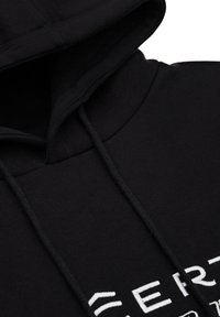 Czarna bluza z kapturem z regulowanym sznurowaniem, o miękkiej fakturze i kontrastowym białym napisem z przodu. Materiały sugerują komfort i ciepło.