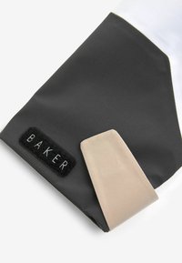 Czarny materiał o fakturowanym wykończeniu, z jasnobeżowym akcentem oraz czarną naszywką z haftem "BAKER" w kolorze białym.