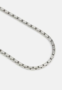 Collier en chaîne en argent avec des maillons ovales au fini lisse et poli, et un design flexible et courbé.