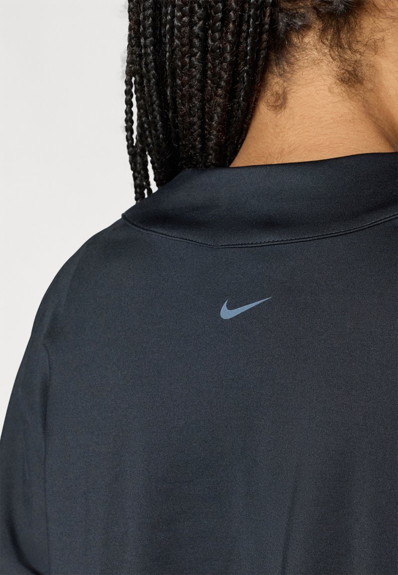 Donkerblauw Nike-shirt met een subtiel logo op de achterkant van de kraag. De stof lijkt glad te zijn met een getailleerd ontwerp en een ronde halslijn.
