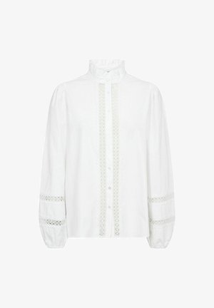 Biela blúzka s vysokým volánovým golierom, s tlačnou prednou stranou a čipkovým lemovaním pozdĺž stredu a rukávov. Plné rukávy s nariasenými manžetami.