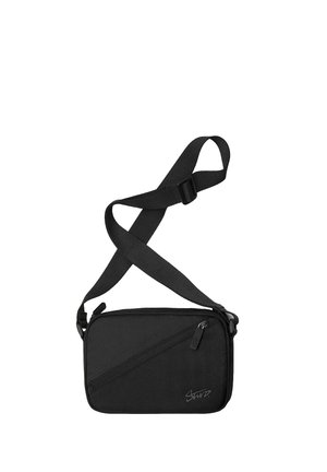 Kompaktná čierna crossbody taška s nastaviteľným popruhom, predným šikmým vreckom na zips a jemným logom v dolnom pravom rohu.