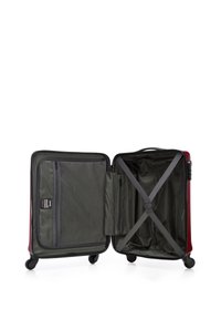 Red hard-shell suitcase with a grey interior, featuring mesh pockets and cross straps for securing contents, and four rolling wheels.