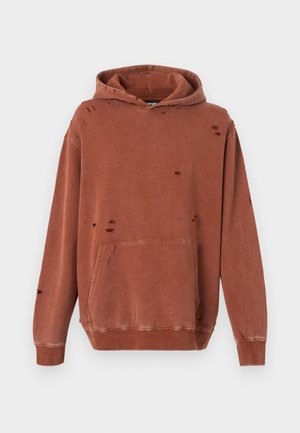 Sweat à capuche couleur rouille en tissu doux. Comprend une poche avant, des détails usés et une capuche avec cordon de serrage. Manches longues avec poignets côtelés.