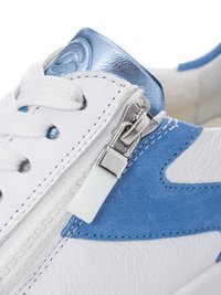 Close-up of white and blue sneaker with white laces and side zipper with a white pull tab on textured leather and suede materials.