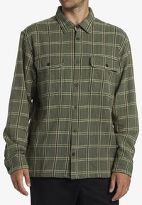 Grønternet flannel skjorte med tekstureret stof, med krave, to brystlommer og frontlukning med knapper; sorte knapper medfølger.