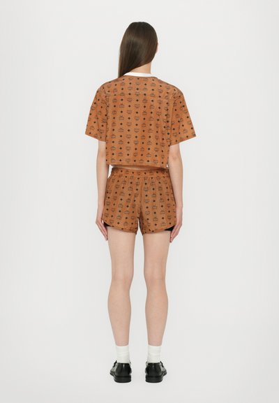 Braunes Baumwoll-T-Shirt und Shorts-Set mit einem Allover-Print-Muster. Das Shirt ist kurz geschnitten mit kurzen Ärmeln, und die Shorts haben einen elastischen Bund.