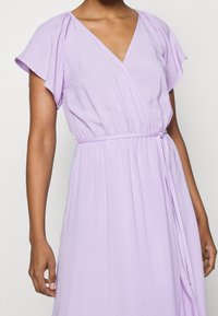 Šaty s krátkými volánovými rukávy v lilkové barvě, hlubokým V-výstřihem, elastickým pasem se stahovací šňůrkou a hladkou, splývavou texturou.