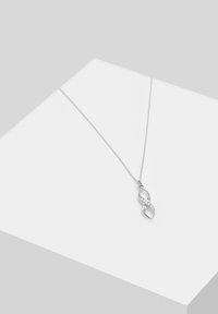 Strieborný náhrdelník s pandantom v tvare nekonečna, ozdobený jasnými kamienkami, umiestnený na jemnom řetízku. Elegantný, minimalistický dizajn.