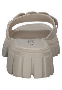 Sandalo platform beige con suola spessa e rigata e retro aperto. Presenta una tomaia liscia e una cinturina arrotondata sulla parte centrale del piede.