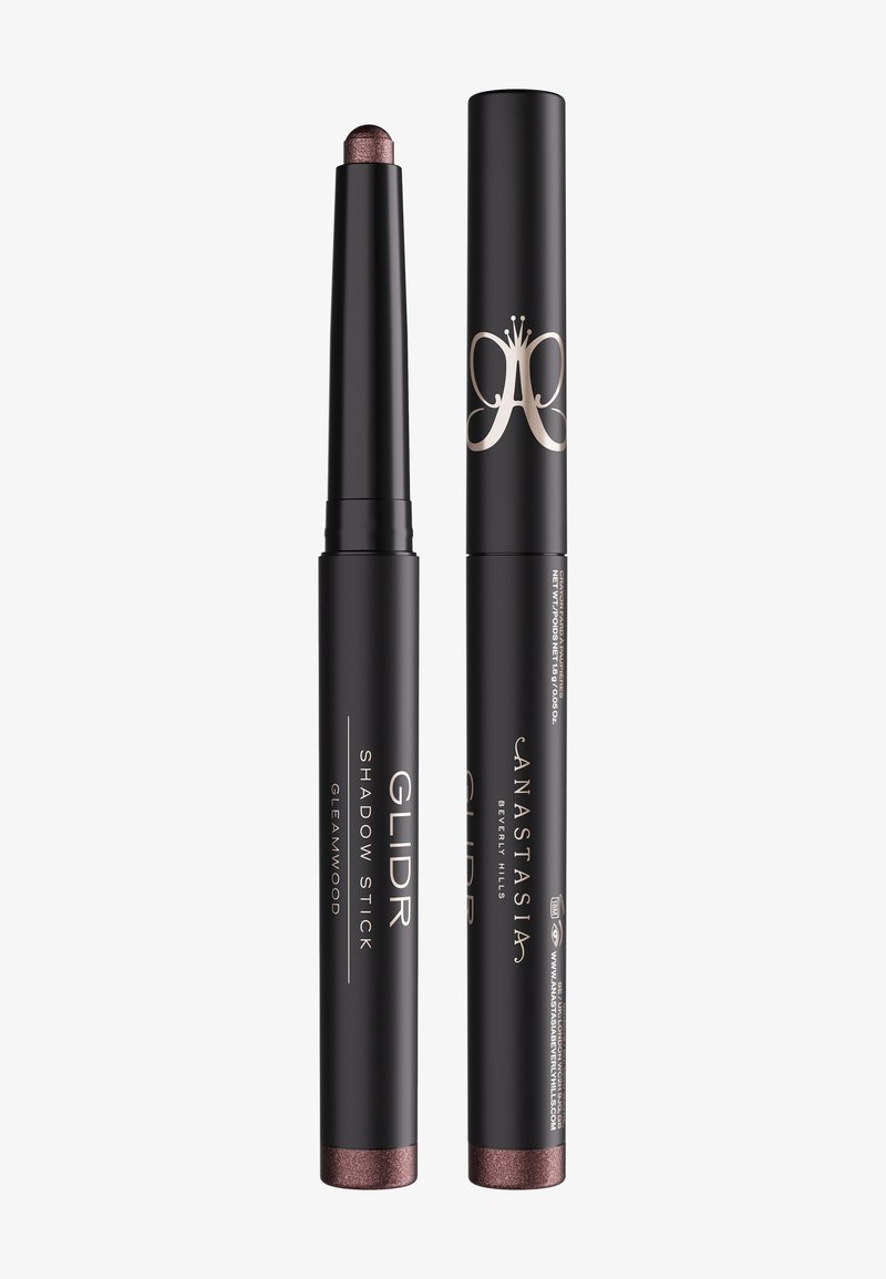 Stick GLIDR Shadow mat noir en teinte Gleamwood, un avec le capuchon retiré montrant une pointe d'ombre à paupières métallique violet-brun, l'autre avec le capuchon.