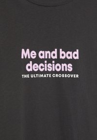 Zwarte stof met roze en witte tekst die luidt "Ik en slechte beslissingen DE ULTIEME CROSSOVER" gecentreerd op het materiaal.