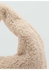 Tissu en peluche beige avec une texture douce et moelleuse ; présente un design en boucles ; forme incurvée mettant en valeur sa qualité tactile et chaleureuse.