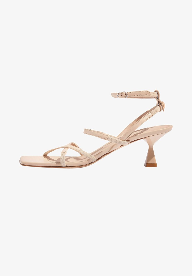 Beżowe sandały na wysokim obcasie z wąskimi krzyżującymi się paskami, kwadratowym noskiem i rzeźbionym stożkowym obcasem. Gładkie wykończenie ze skóry oraz regulowany pasek na kostce.