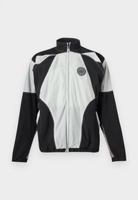 Μαύρο και γκρι αθλητικό μπουφάν με φερμουάρ και ψηλό γιακά, με στρογγυλή λωρίδα λογότυπου στο αριστερό στήθος, εμφανισμένο σε λευκό φόντο.