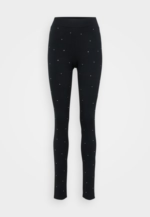 Zwarte leggings met een aansluitend ontwerp, gemaakt van rekbaar materiaal, versierd met verspreide metalen studs voor een extra detail.