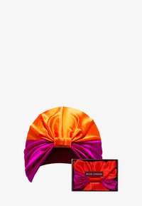 Silkkisellä turbanilla oranssia ja pinkkiä väriä, jossa solmu edessä. Mukana on yhteensopiva silkkinen laatikko säilytystä varten. Teksturoitu satiinipinta.