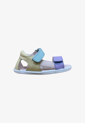 Sandalia infantil de puntera abierta con parte trasera beige, tira azul clara en el tobillo y tira frontal púrpura sobre suela blanca, aislada sobre fondo blanco.