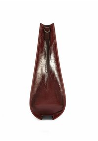 Burgundowa skórzana torba o eleganckim, wygiętym kształcie. Błyszcząca tekstura, z górną pętlą do noszenia. Gładkie, minimalistyczne wykończenie.
